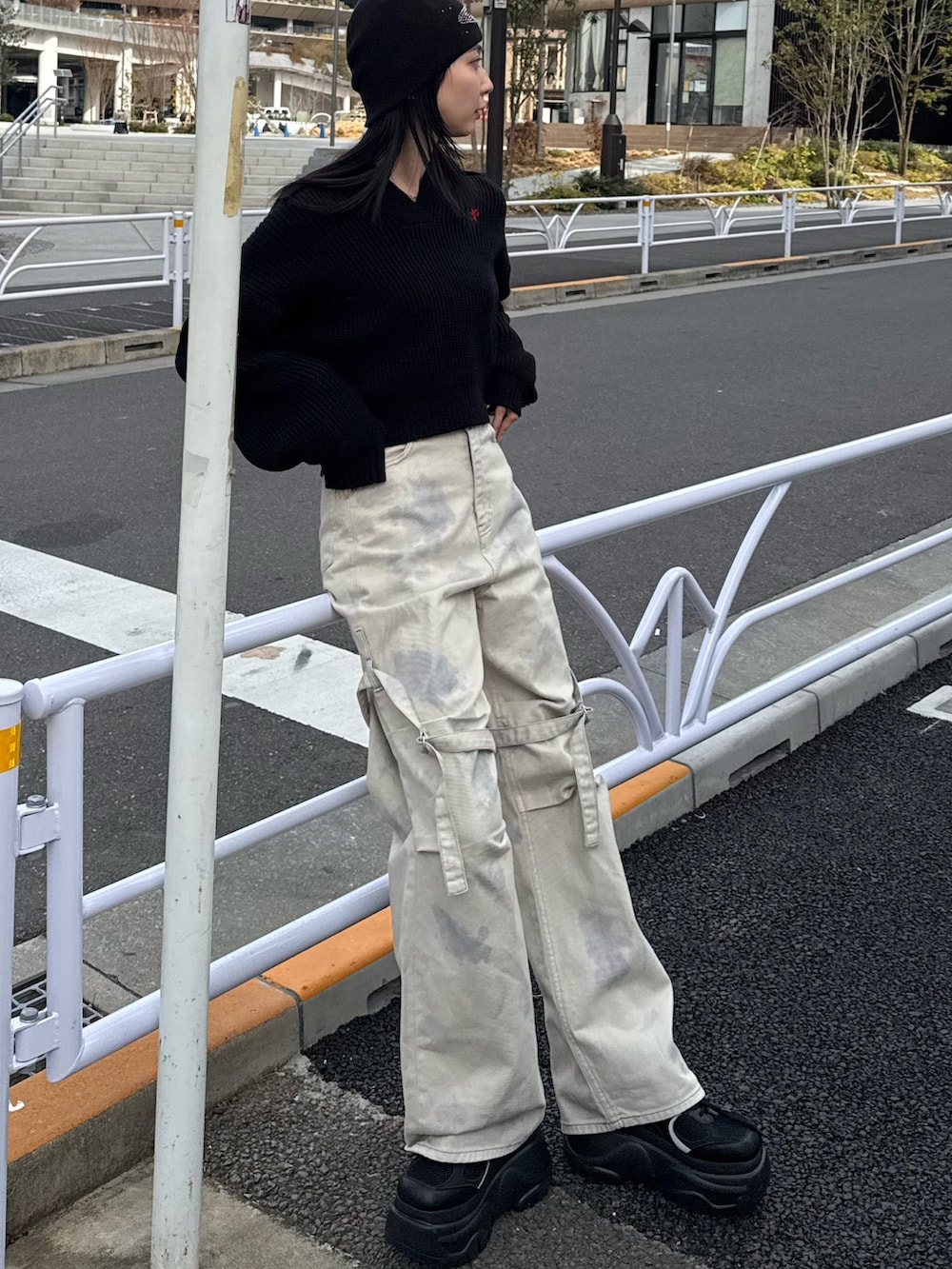 ホワイト系のデニムパンツ、ブラック系のニット/セーター、ブラック系のスニーカーを着用したレディースの冬コーディネートの3枚目の写真