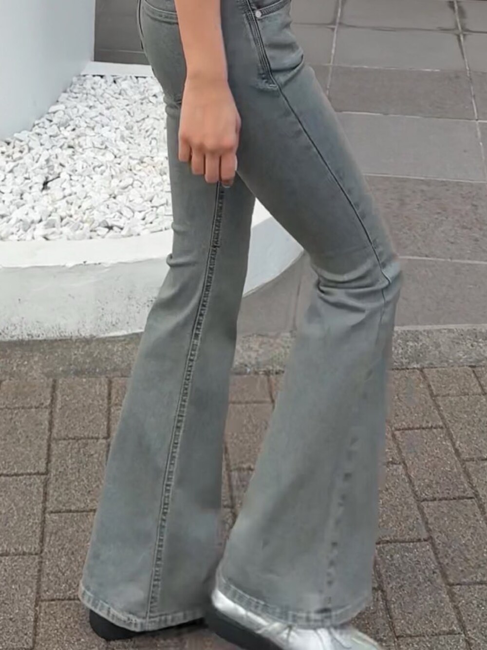 ブルー系のデニムパンツ、ホワイト系のTシャツ/カットソー、シルバー系のスニーカーを着用したレディースの春コーディネートの4枚目の写真