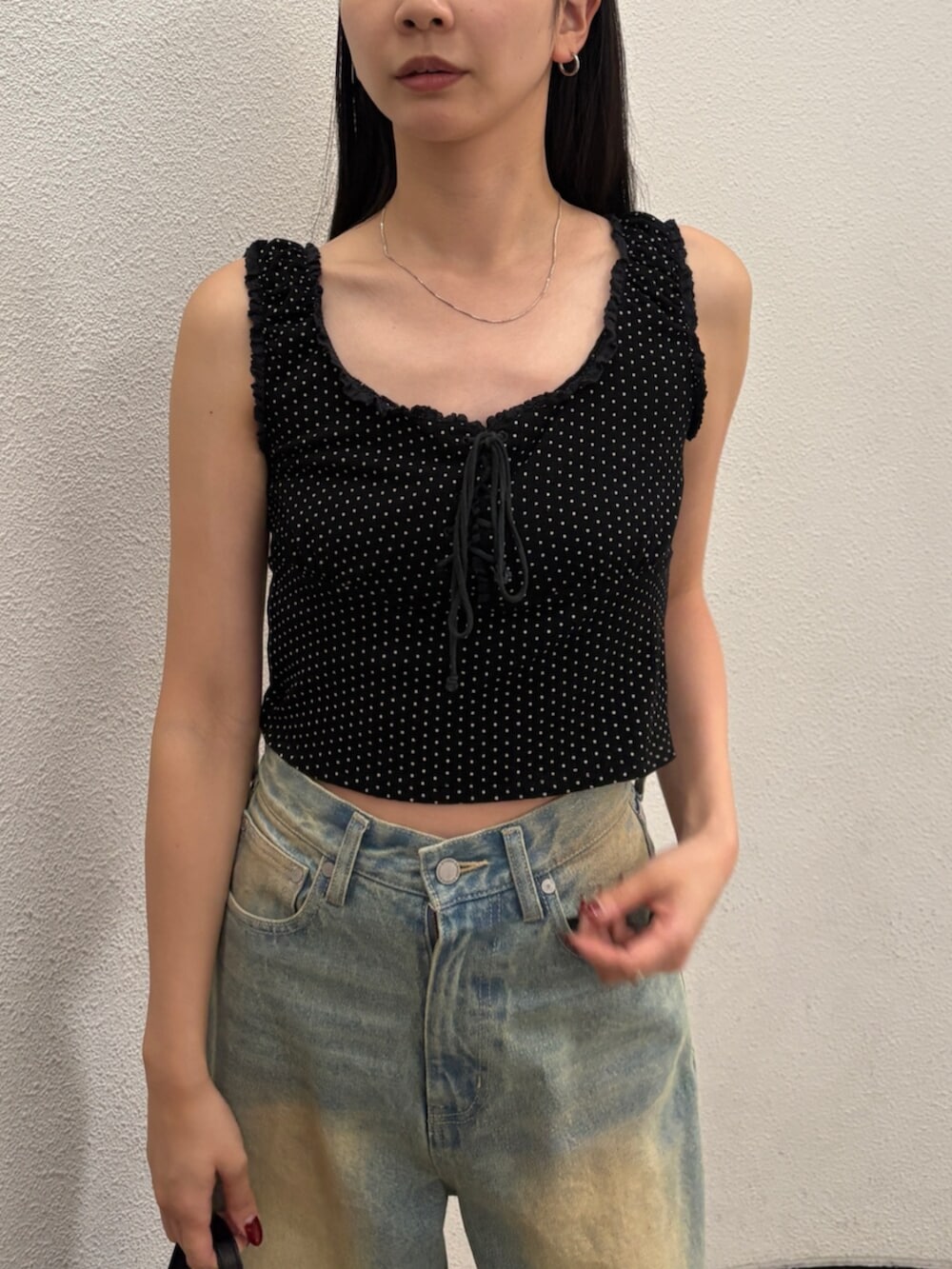 ブルー系のデニムパンツ、ブラック系のハンドバッグ、ブラック系のサンダルを着用したレディースの夏コーディネートの6枚目の写真