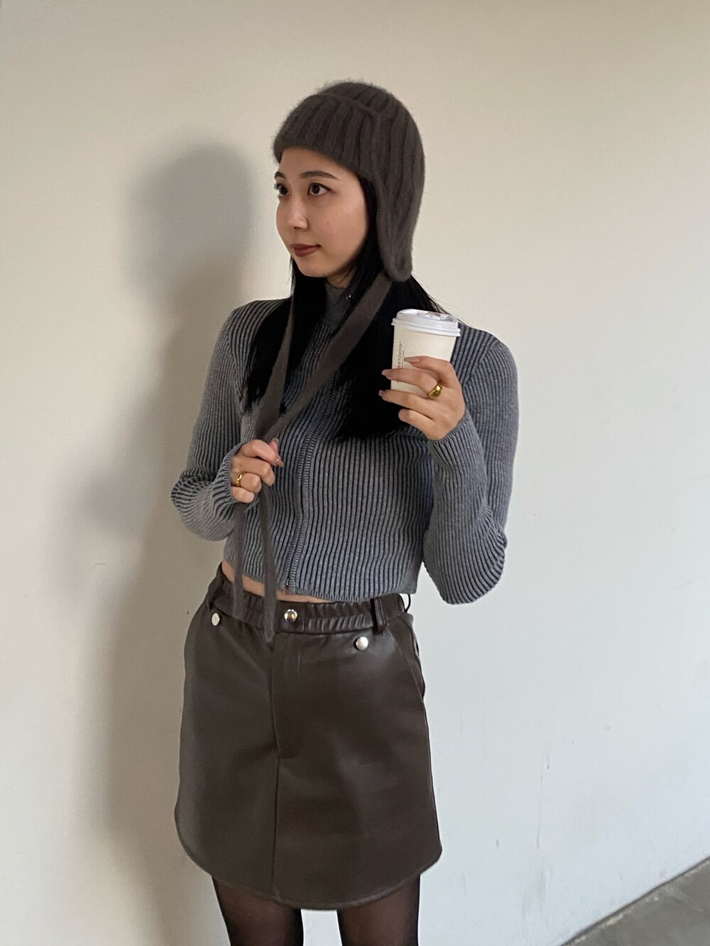 ブラウン系のスカート、グレー系のニット/セーターを着用したレディースの冬コーディネートの2枚目の写真