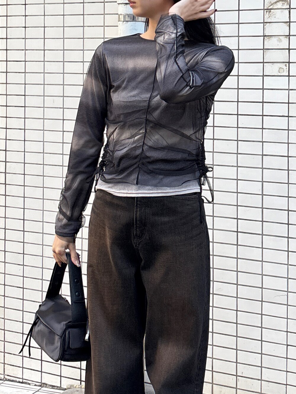 ブラック系のデニムパンツ、ブラック系のハンドバッグ、ブラック系のTシャツ/カットソーを着用したレディースの春コーディネートの3枚目の写真