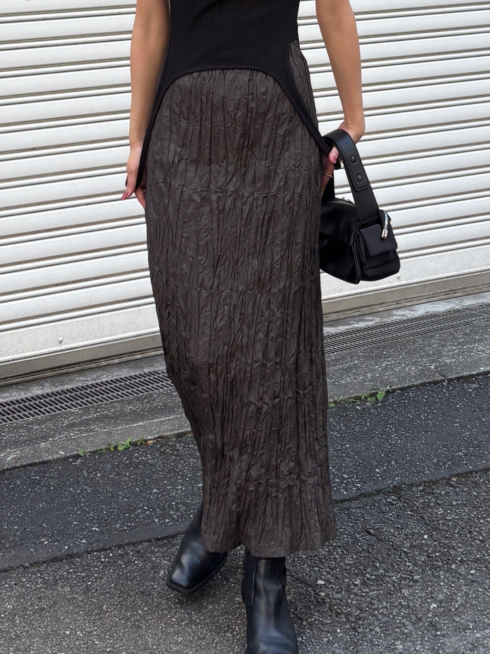 ブラウン系のスカート、ブラック系のTシャツ/カットソーを着用したレディースの夏コーディネートの3枚目の写真