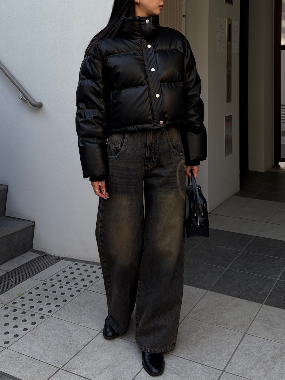 ブルー系のデニムパンツ、ブラック系のダウンジャケット/コートを着用したレディースの冬コーディネートの4枚目の写真