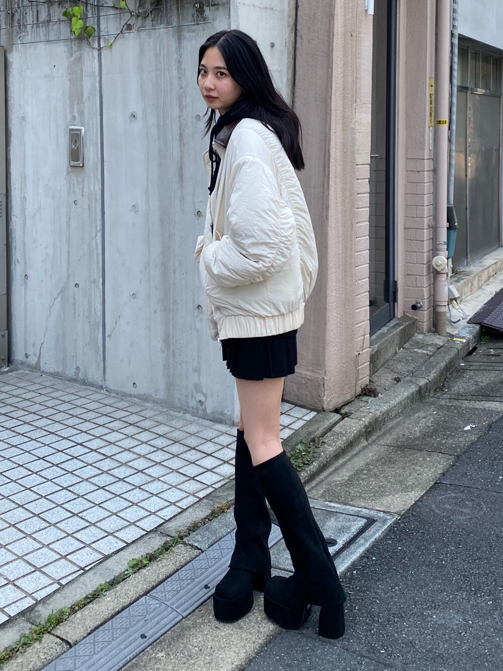 グレー系のブルゾン、ブラック系のパーカー、ブラック系のブーツを着用したレディースの夏コーディネートの2枚目の写真