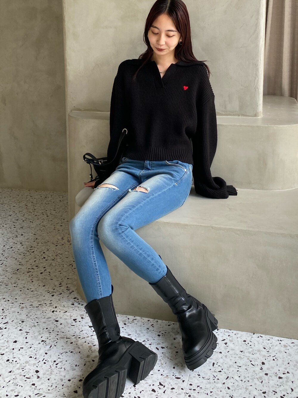 ブラック系のニット/セーターを着用したレディースの冬コーディネートの2枚目の写真