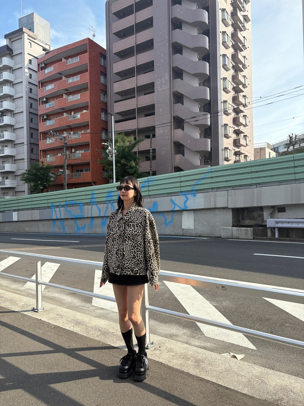 ホワイト系のブルゾン、ブラック系のスカート、ブラック系のローファーを着用したレディースの秋コーディネートの2枚目の写真