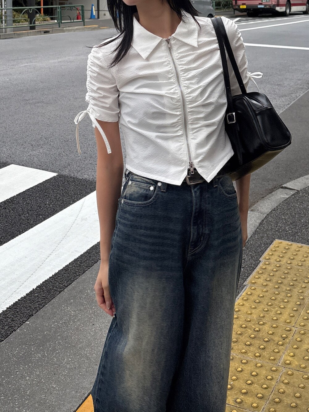 ブルー系のデニムパンツ、ブラック系のサンダル、ホワイト系のシャツ/ブラウスを着用したレディースの春コーディネートの2枚目の写真