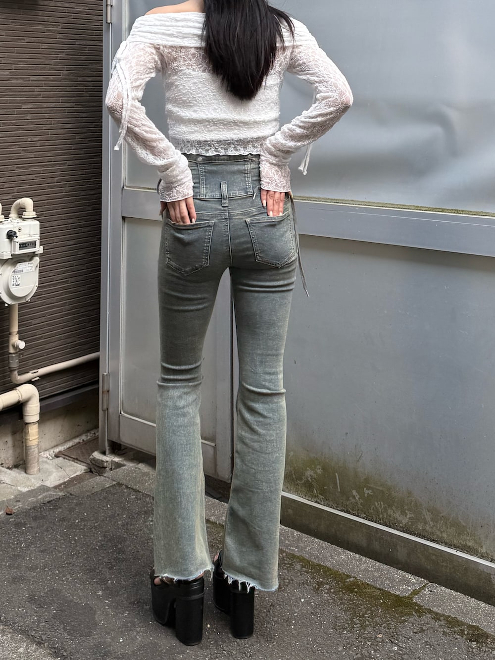 ブルー系のデニムパンツ、ブラック系のサンダル、ホワイト系のTシャツ/カットソーを着用したレディースの春コーディネートの2枚目の写真