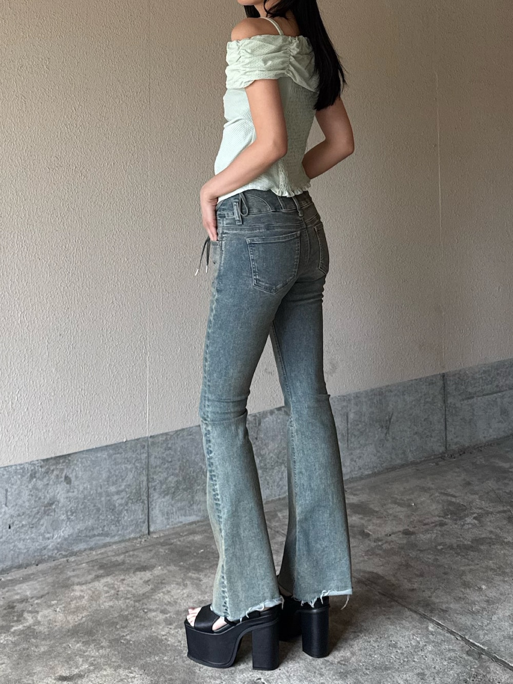 ブラック系のサンダル、ブルー系のデニムパンツ、グリーン系のTシャツ/カットソーを着用したレディースの夏コーディネートの2枚目の写真