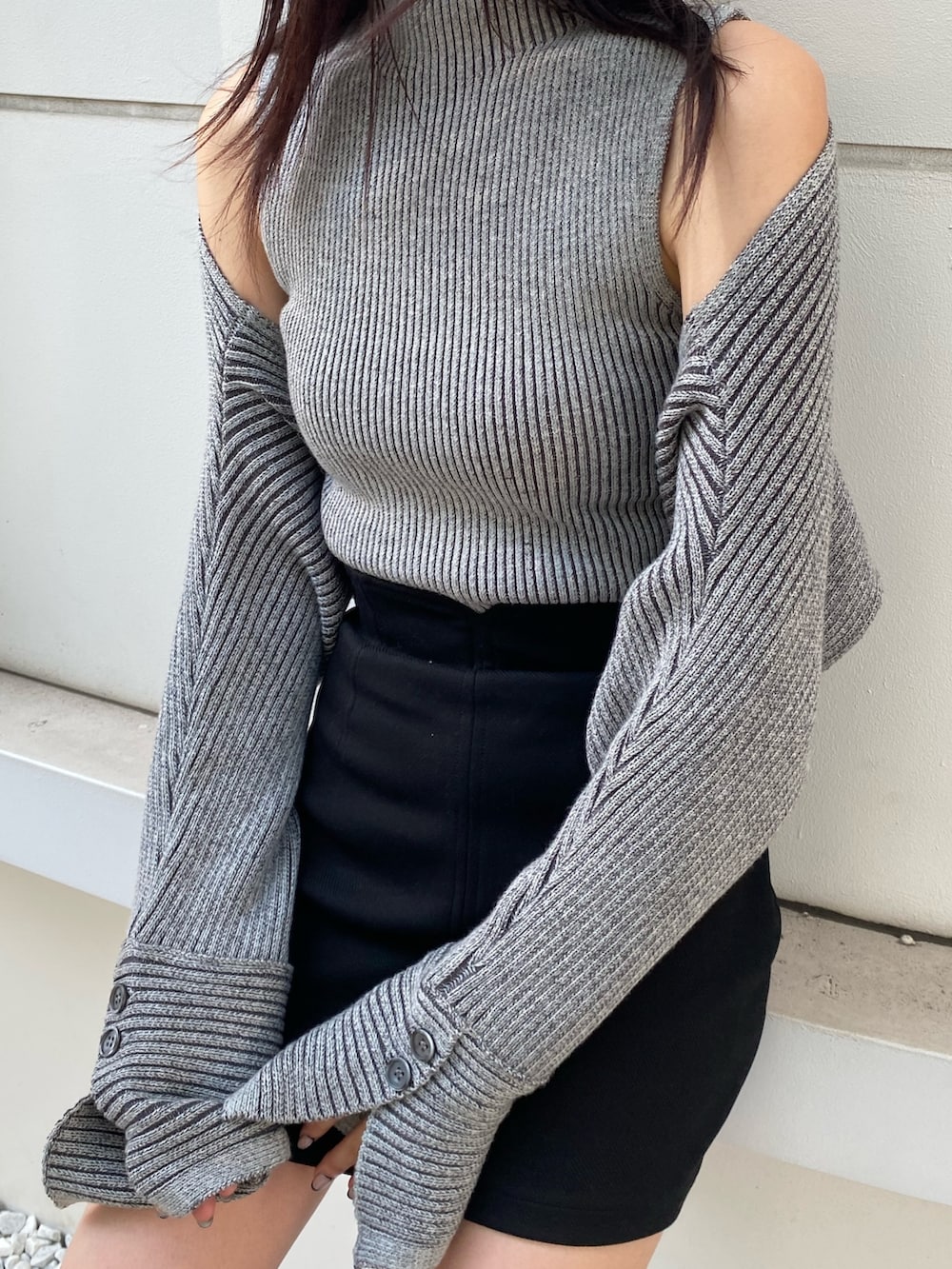 グレー系のニット/セーター、ブラック系のスカート、ブラック系のブーツを着用したレディースの夏コーディネートの5枚目の写真