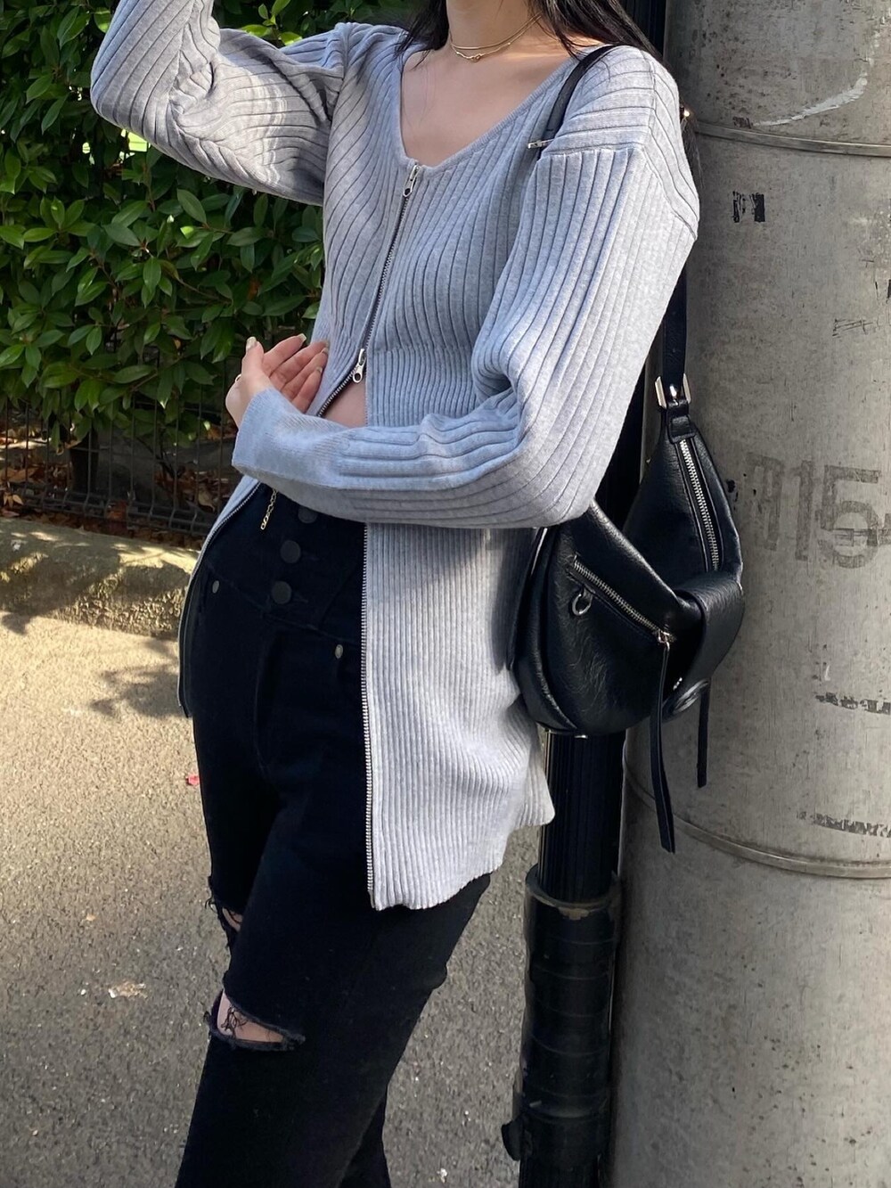 ブラック系のデニムパンツ、グレー系のニット/セーター、ブラック系のブーツを着用したレディースの冬コーディネートの2枚目の写真