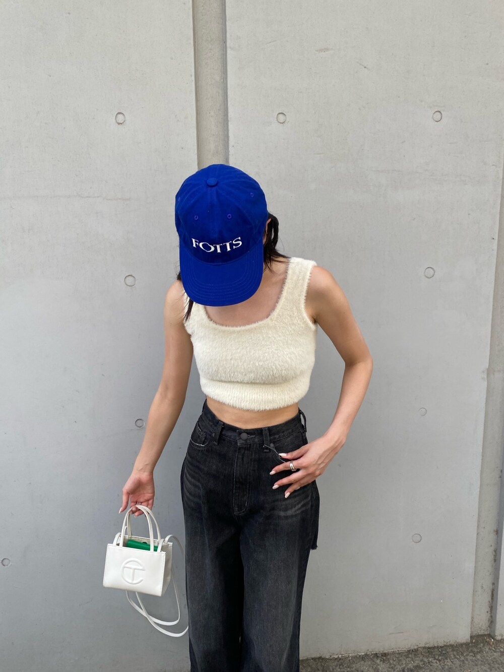 ブラック系のデニムパンツ、ホワイト系のニット/セーターを着用したレディースの秋コーディネートの2枚目の写真