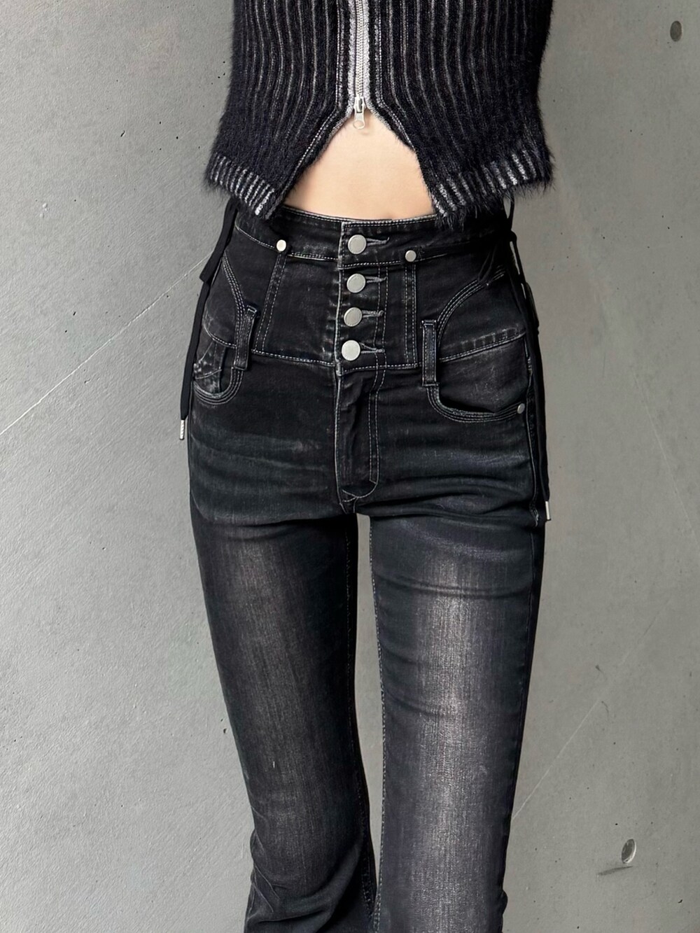 ブラック系のブーツ、ブラック系のデニムパンツ、ブラック系のニット/セーターを着用したレディースの秋コーディネートの3枚目の写真