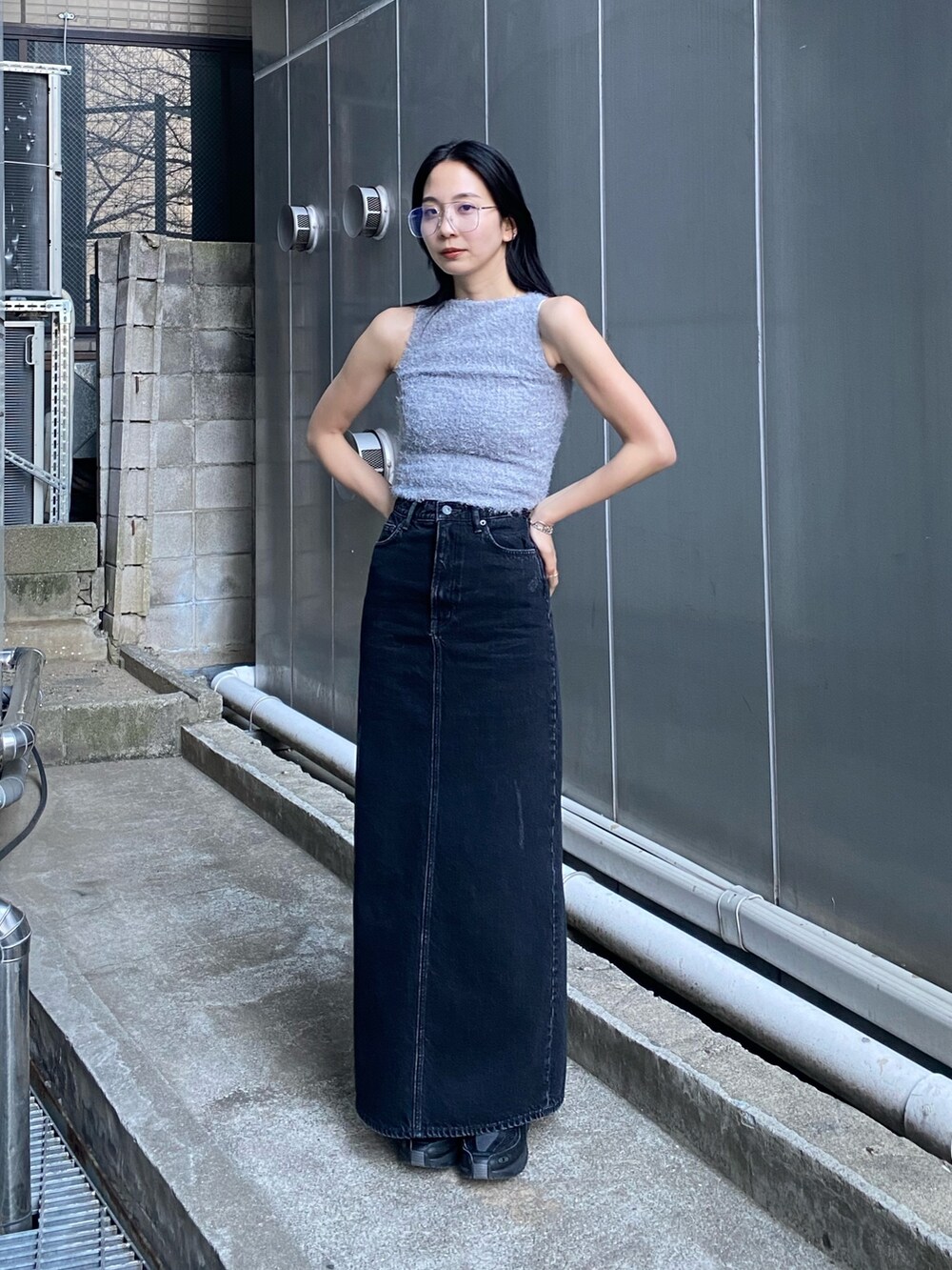 ブラック系のスカート、グレー系のタンクトップを着用したレディースの春コーディネートの2枚目の写真