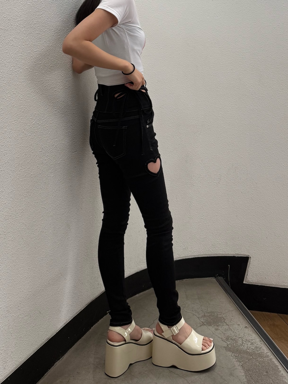 ブラック系のデニムパンツ、ホワイト系のTシャツ/カットソー、ホワイト系のサンダルを着用したレディースの春コーディネートの2枚目の写真