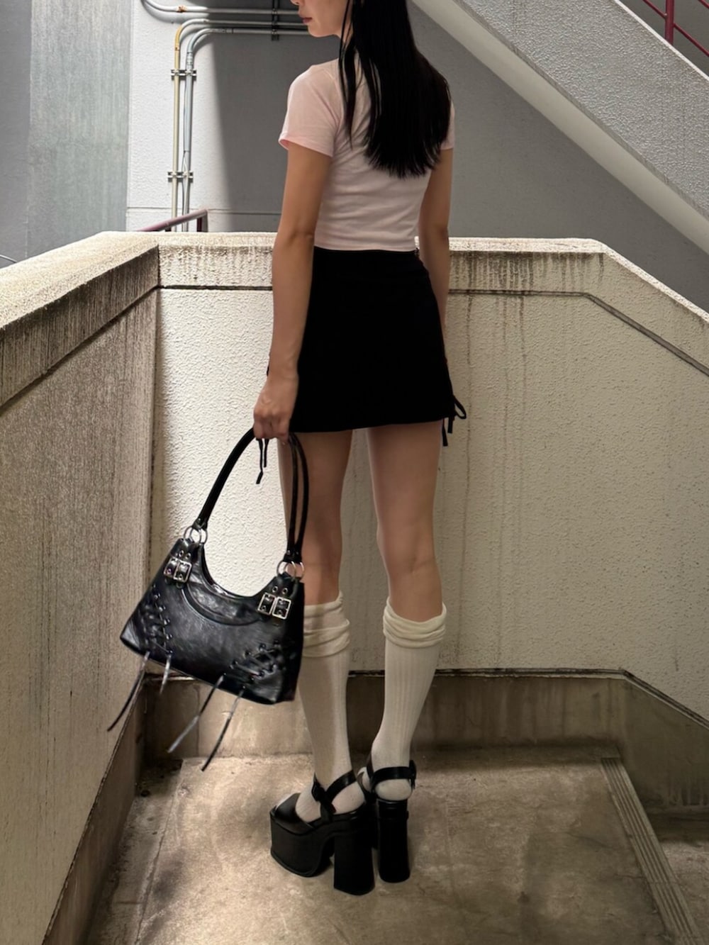 ブラック系のサンダル、ブラック系のショルダーバッグ、ピンク系のTシャツ/カットソーを着用したレディースの夏コーディネートの4枚目の写真