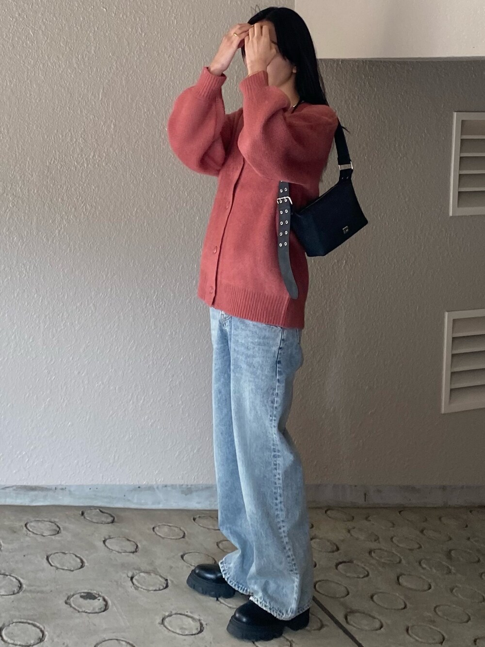 ピンク系のカーディガン/ボレロ、ブルー系のデニムパンツを着用したレディースの冬コーディネートの2枚目の写真