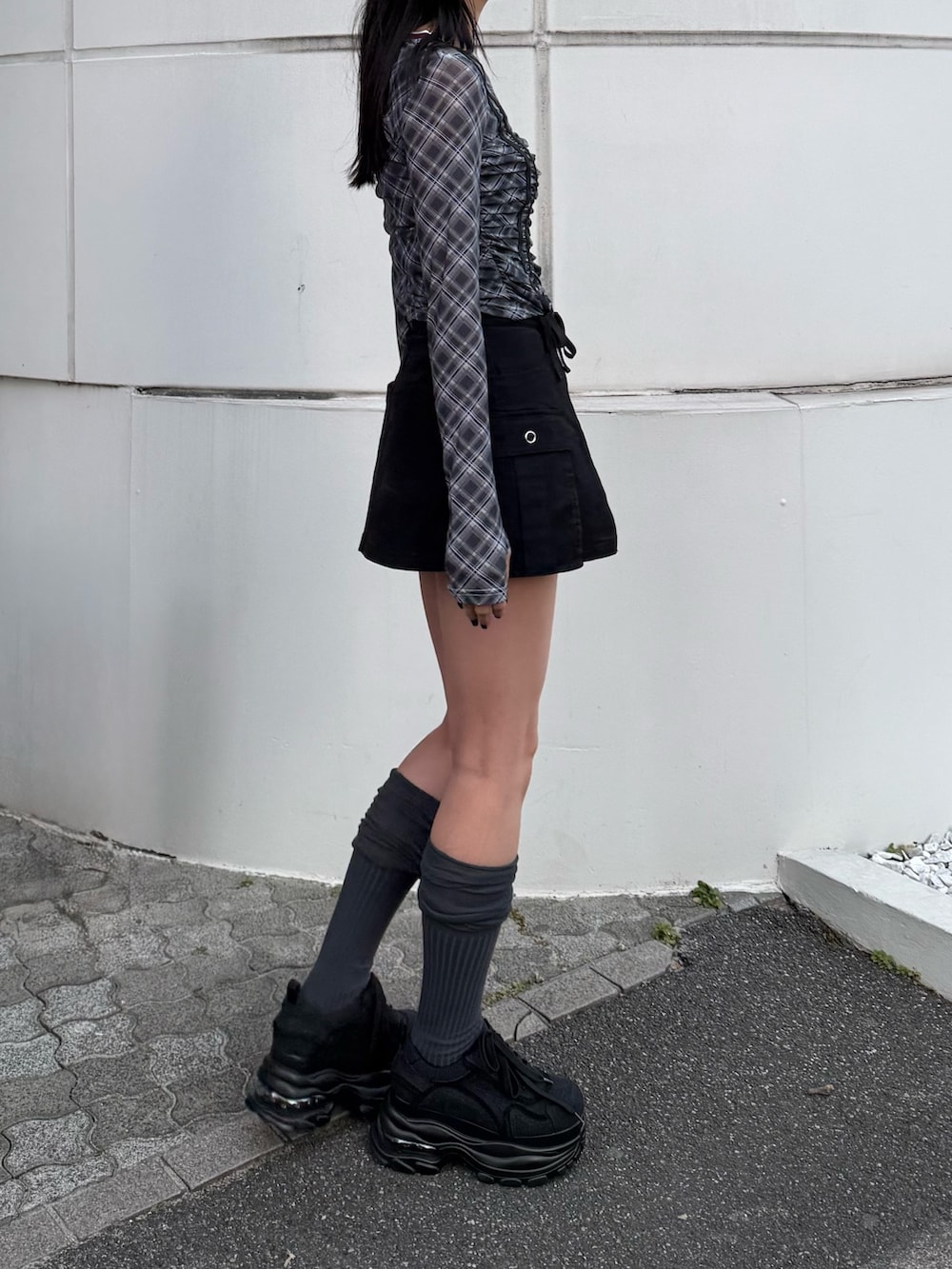 ブラック系のTシャツ/カットソー、ブラック系のスニーカー、ブラック系のスカートを着用したレディースの冬コーディネートの3枚目の写真