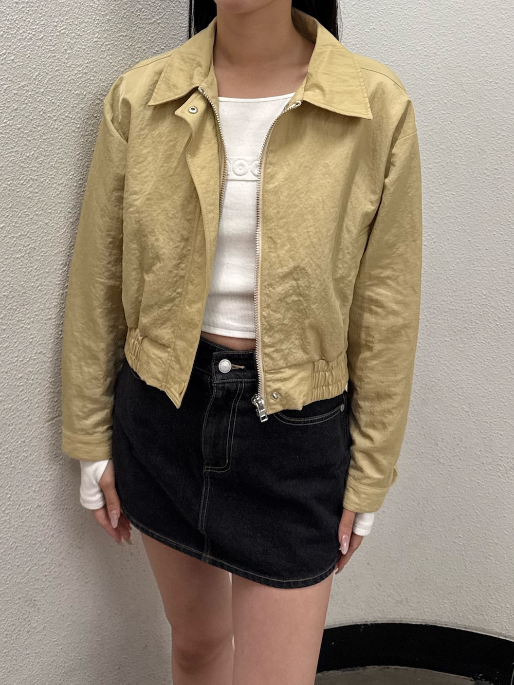 ブラウン系のブーツ、イエロー系のブルゾン、ホワイト系のTシャツ/カットソーを着用したレディースの冬コーディネートの2枚目の写真