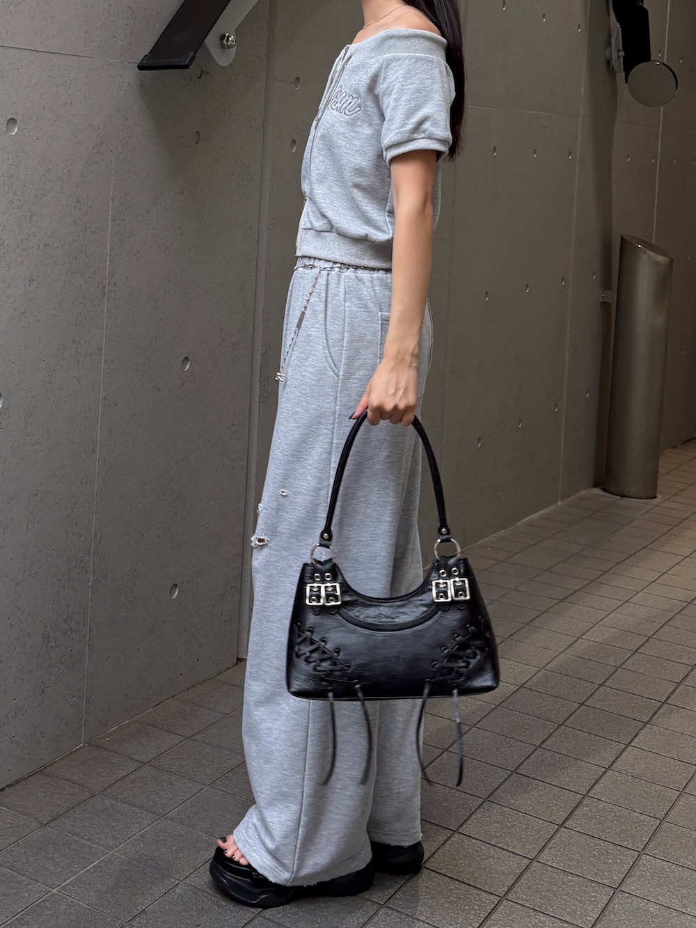 グレー系のスウェットパンツ、グレー系のスウェット、ブラック系のサンダルを着用したレディースの夏コーディネートの2枚目の写真