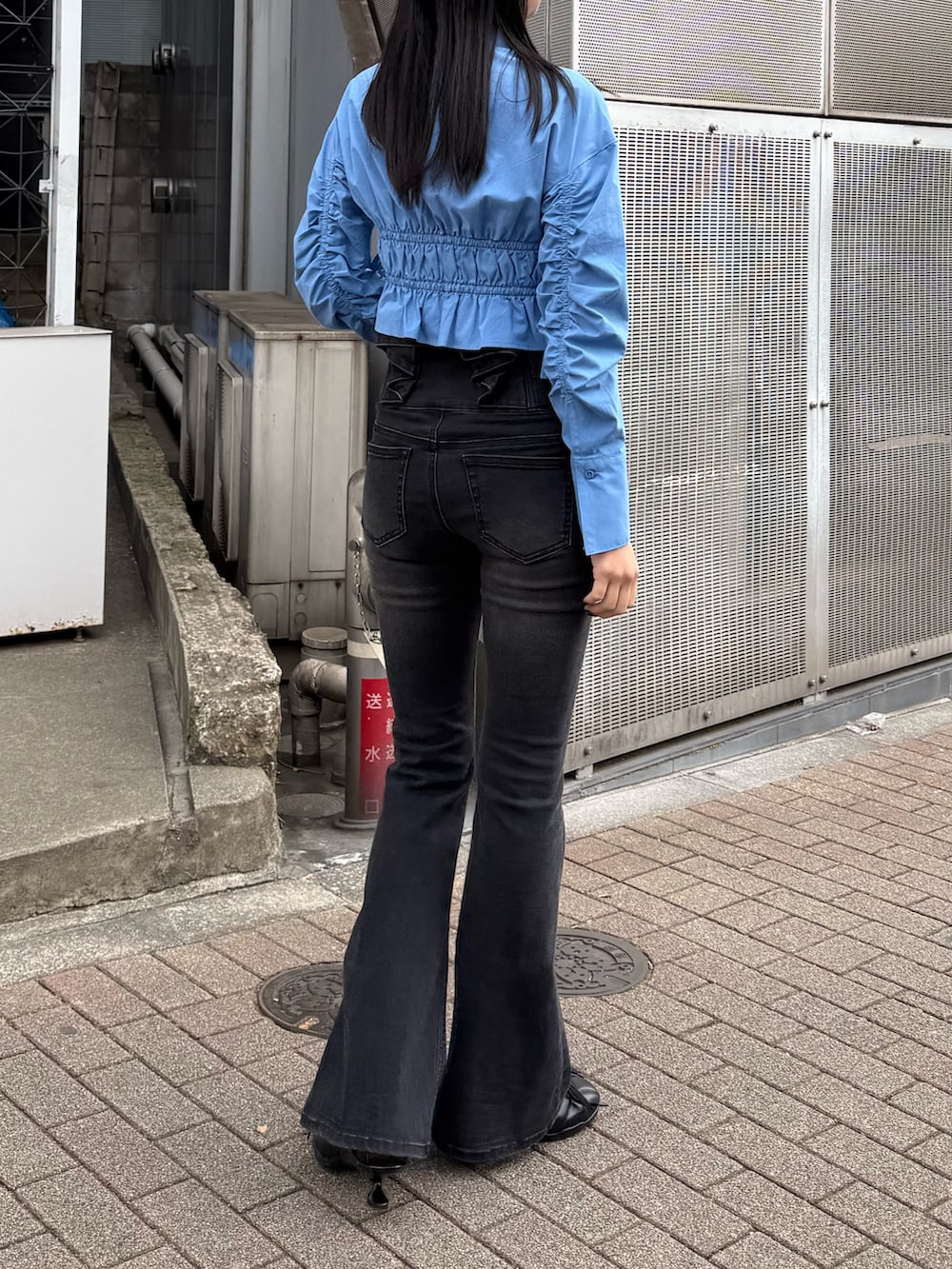 ブラック系のデニムパンツ、ブルー系のシャツ/ブラウス、ブラック系のスニーカーを着用したレディースの冬コーディネートの2枚目の写真