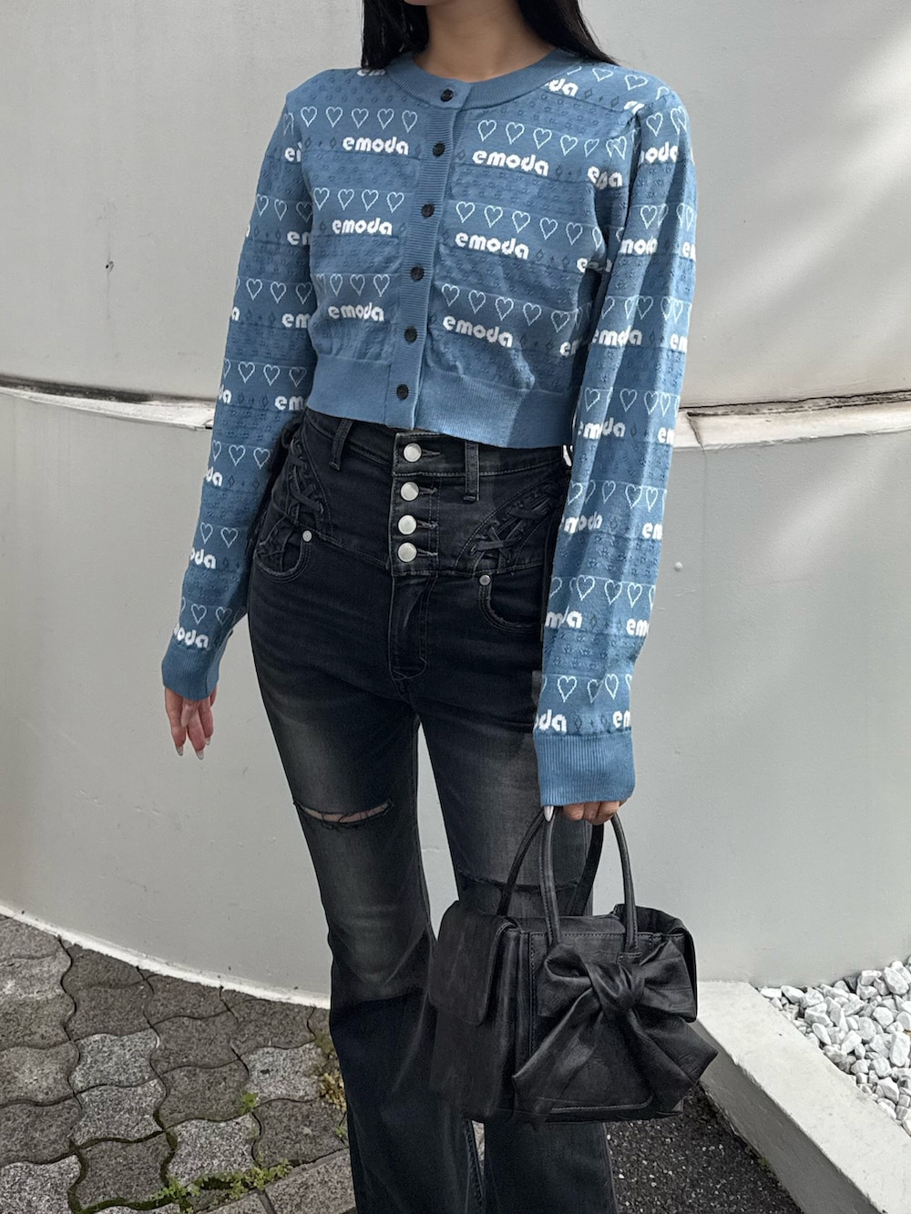 ブルー系のニット/セーター、ブラック系のデニムパンツ、ブラック系のローファーを着用したレディースの冬コーディネートの2枚目の写真