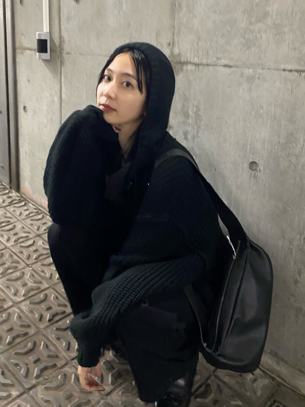 ブラック系のニット/セーター、ブラック系のデニムパンツを着用したレディースの秋コーディネートの3枚目の写真