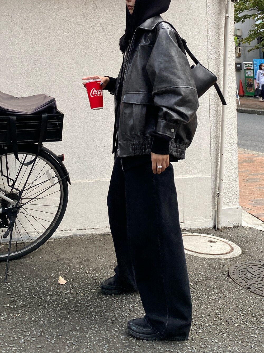 ブラック系のデニムパンツ、グレー系のブルゾン、ブラック系のパーカーを着用したレディースの秋コーディネートの2枚目の写真