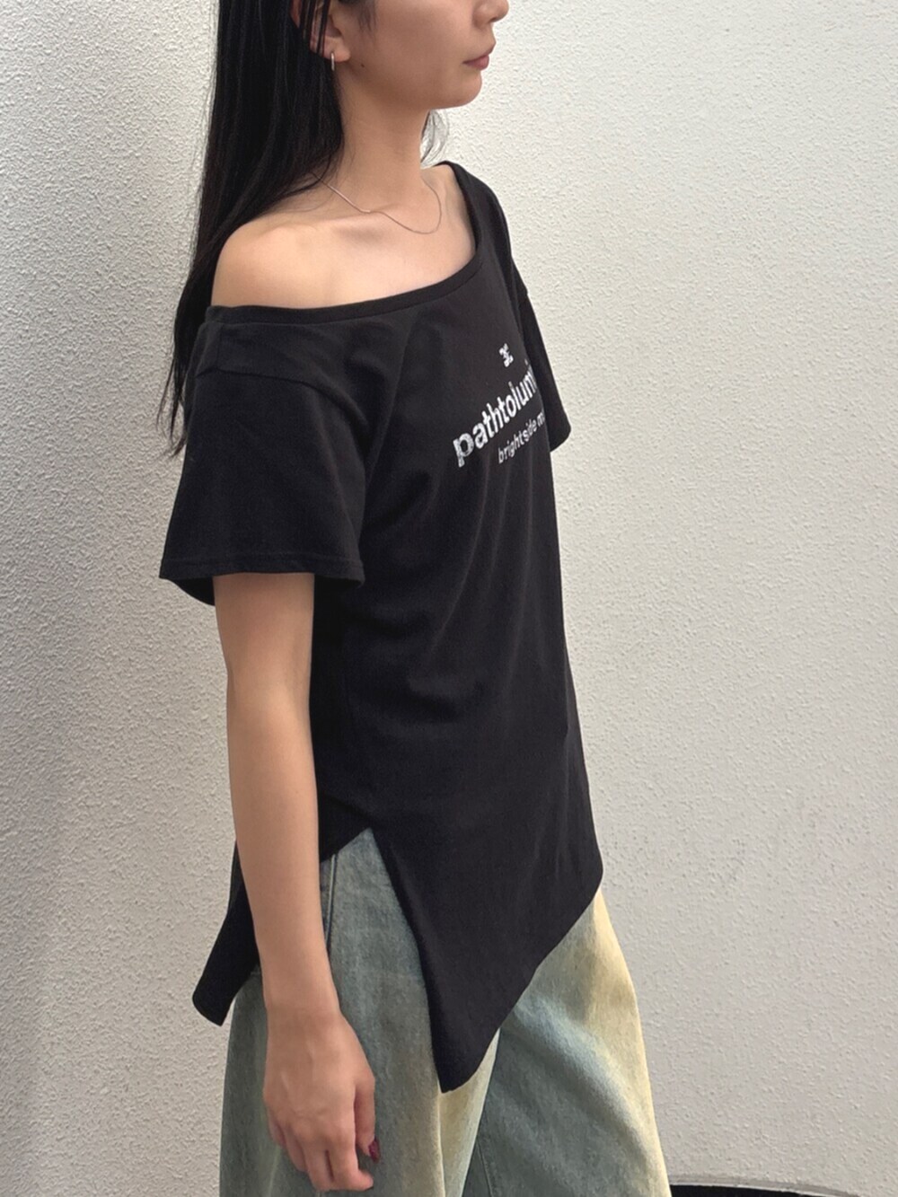 ブルー系のデニムパンツ、ブラック系のハンドバッグ、ブラック系のTシャツ/カットソーを着用したレディースの夏コーディネートの5枚目の写真
