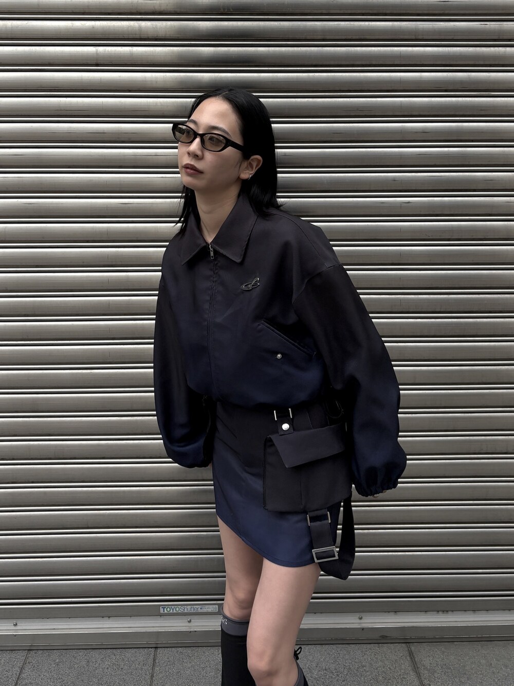 ブルー系のブルゾン、ブルー系のスカート、ブラック系のスニーカーを着用したレディースの冬コーディネートの3枚目の写真