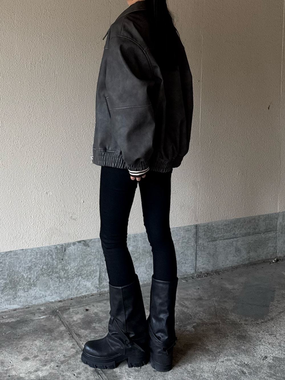 ブラック系のデニムパンツ、グレー系のブルゾン、ブラウン系のニット/セーターを着用したレディースの冬コーディネートの2枚目の写真