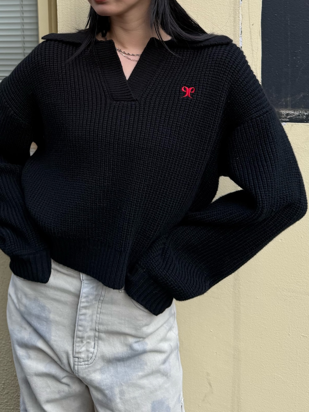 ホワイト系のデニムパンツ、ブラック系のニット/セーター、ブラック系のスニーカーを着用したレディースの冬コーディネートの5枚目の写真