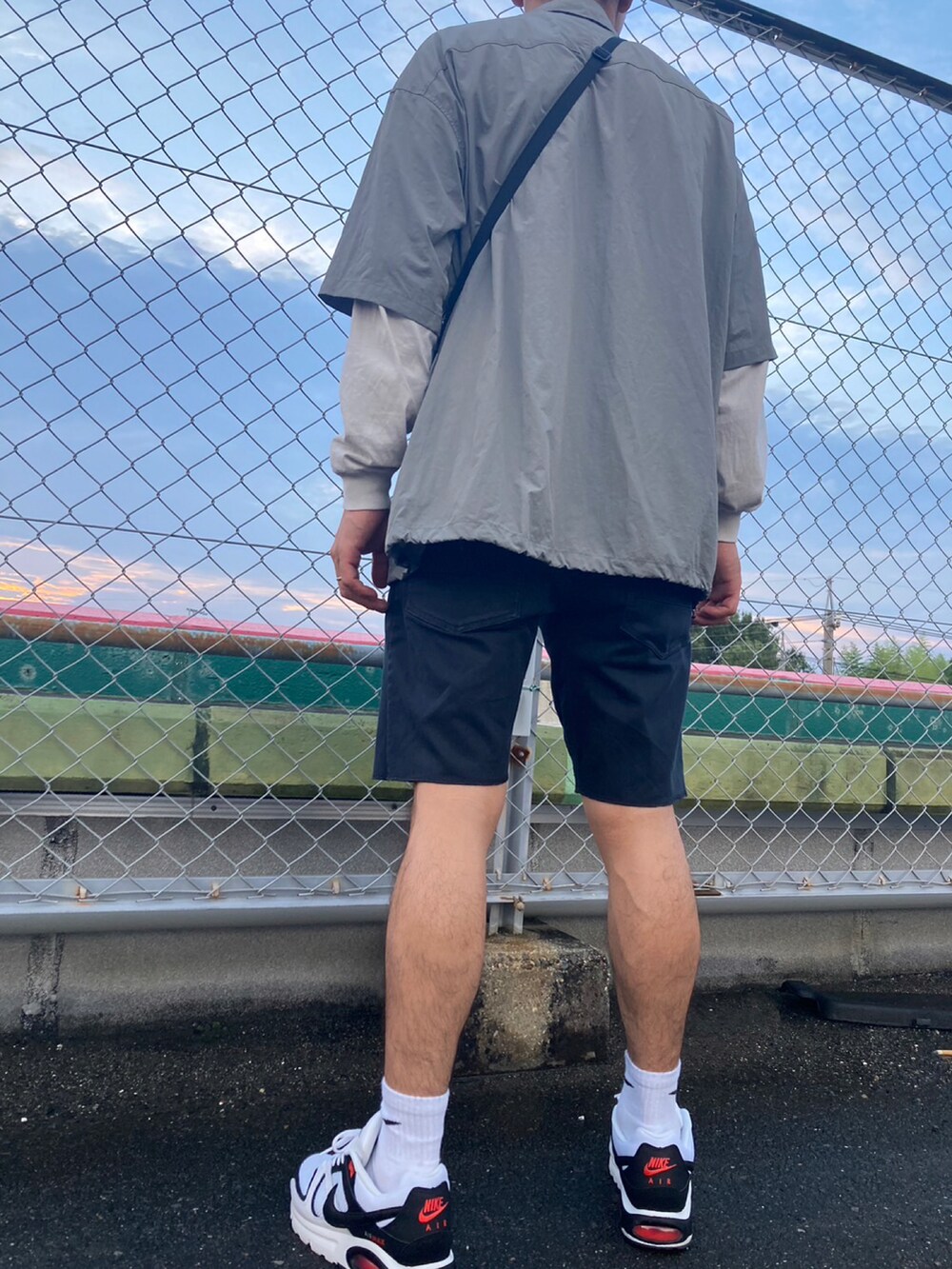 ブラック系のショルダーバッグ、グレー系のその他アウター、グレー系のTシャツ/カットソーを着用したメンズの夏コーディネートの3枚目の写真