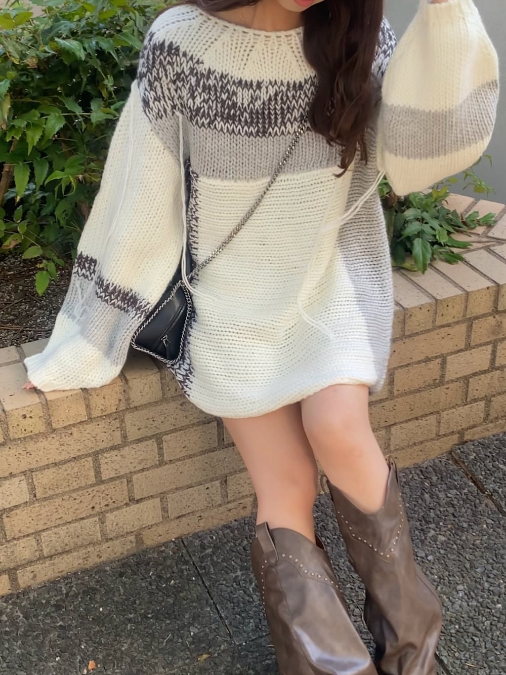 ブラウン系のブーツ、グレー系のニット/セーターを着用したレディースの秋コーディネートの2枚目の写真