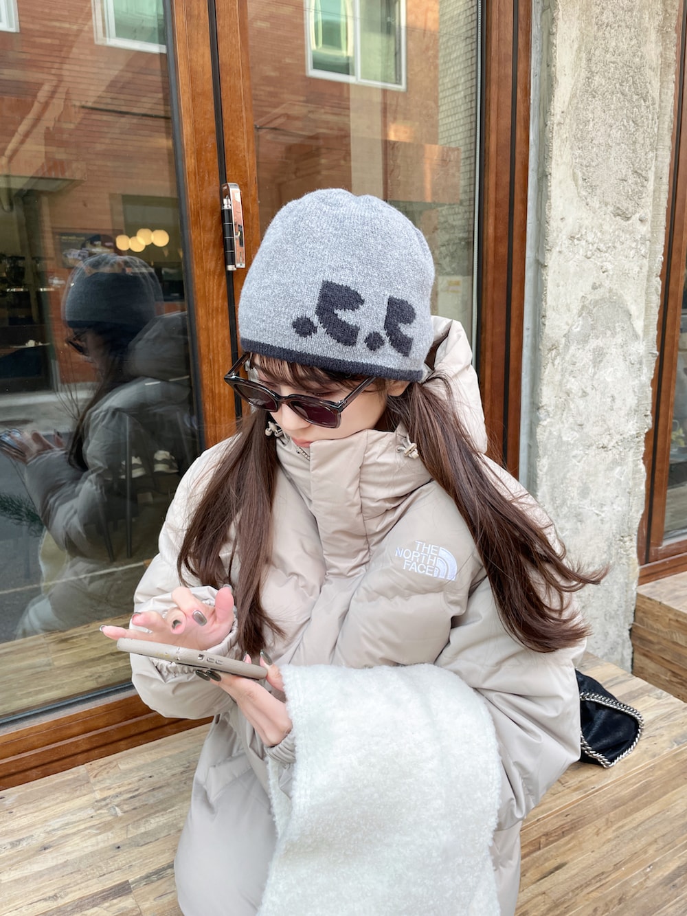 ベージュ系のスラックス、ベージュ系のダウンジャケット/コート、ブラウン系のスニーカーを着用したレディースの冬コーディネートの2枚目の写真