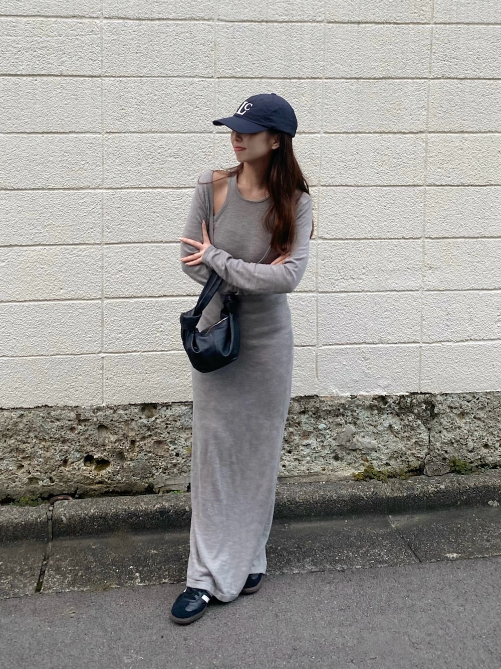 グレー系のワンピース、ブラック系のスニーカー、ブラック系のハンドバッグを着用したレディースの秋コーディネートの3枚目の写真