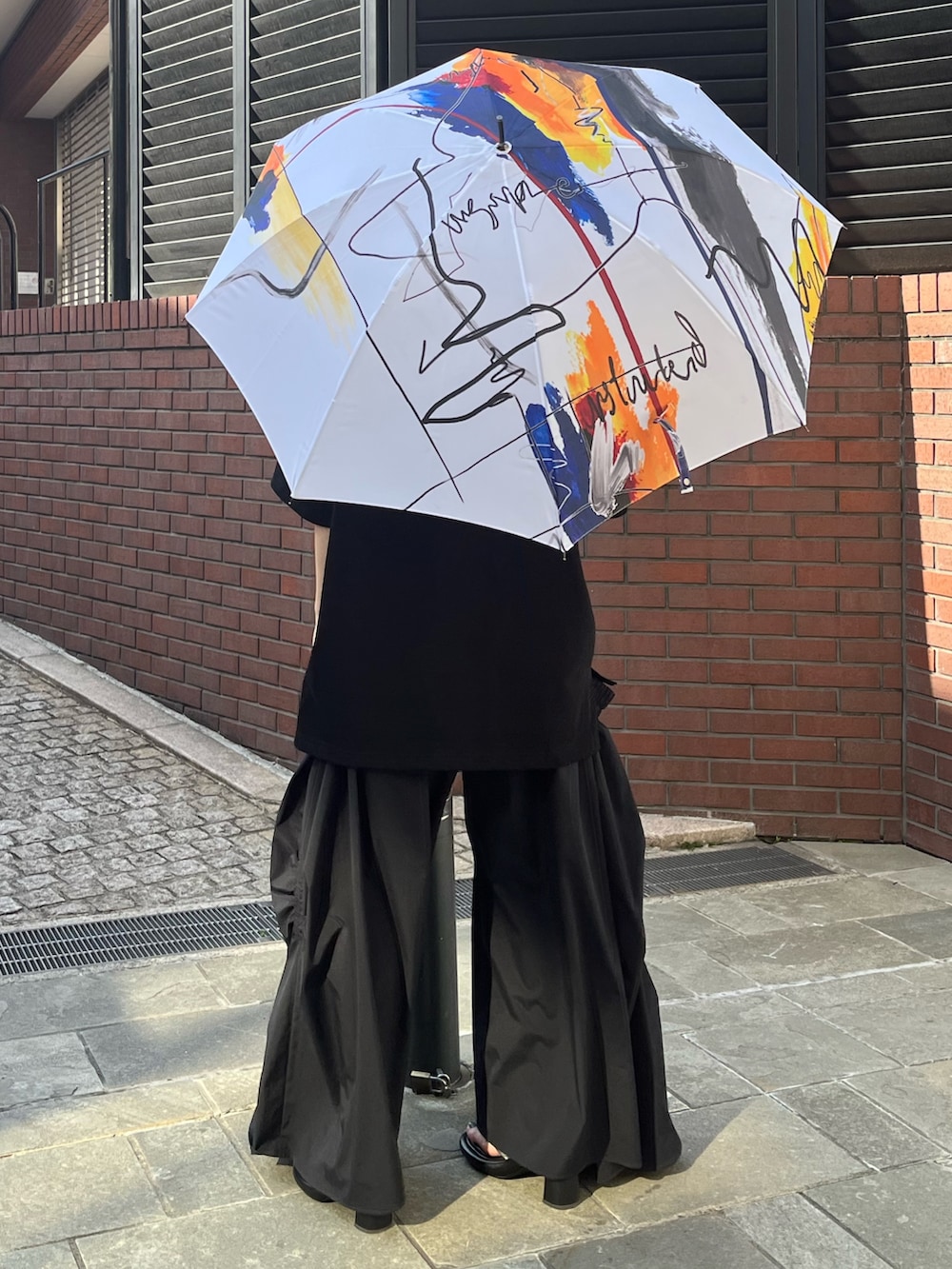 ブラック系のTシャツ/カットソー、ブラック系のその他パンツ、シルバー系のサンダルを着用したレディースの春コーディネートの3枚目の写真