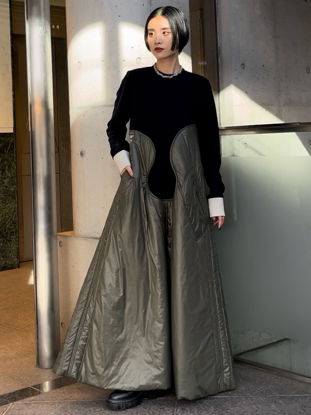 ベージュ系のワンピース、ブラック系のブーツ、シルバー系のネックレスを着用したレディースの秋コーディネートの2枚目の写真