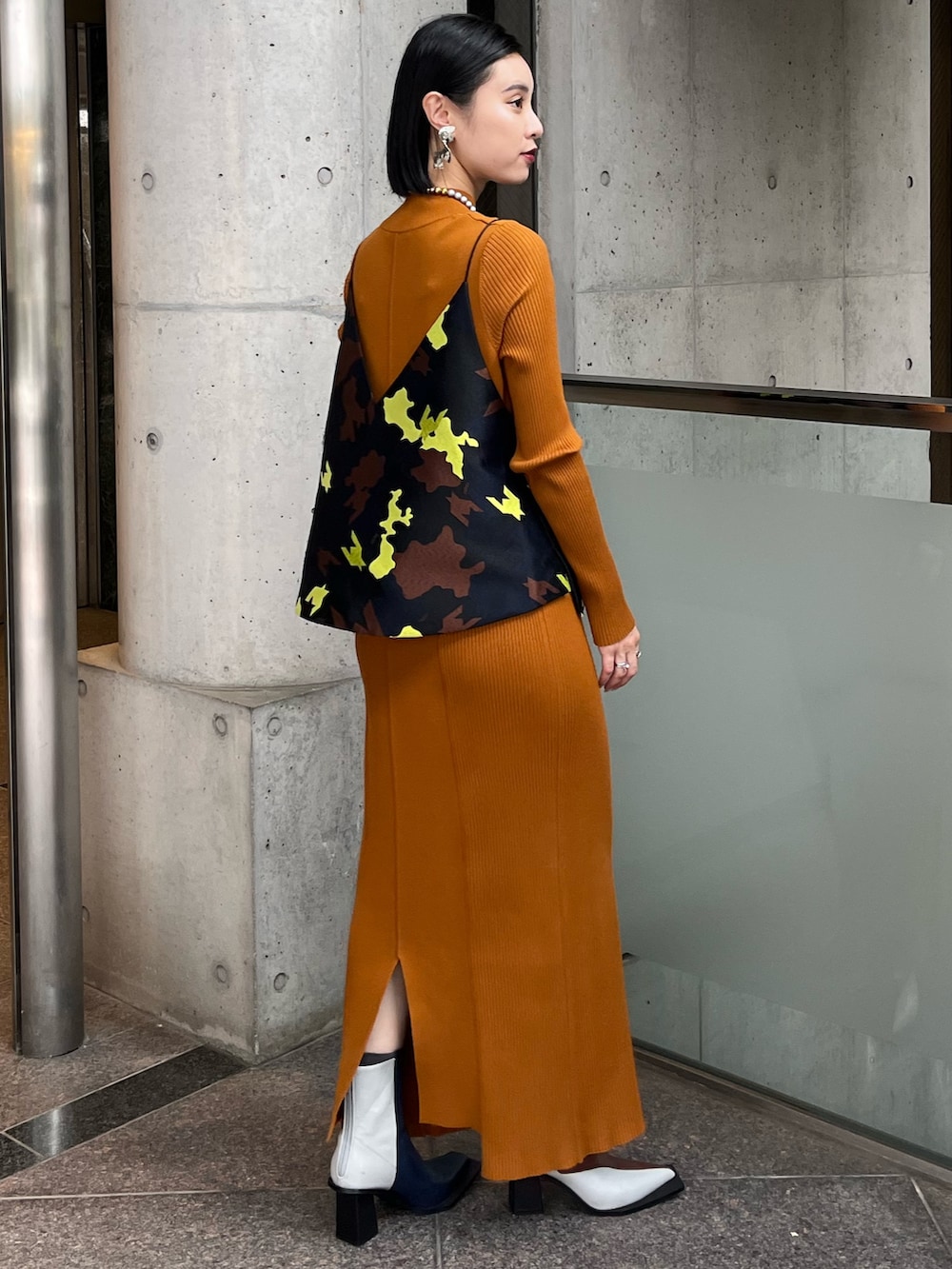 イエロー系のワンピース、ブラック系のキャミソール、その他のブーツを着用したレディースの秋コーディネートの2枚目の写真