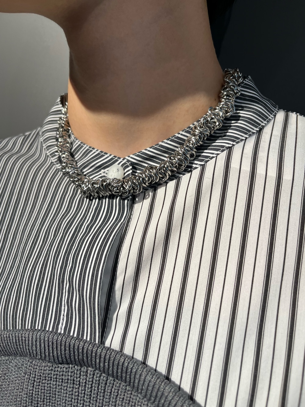 グレー系のシャツ/ブラウス、ブラック系のスカート、シルバー系のブーツを着用したレディースの秋コーディネートの7枚目の写真