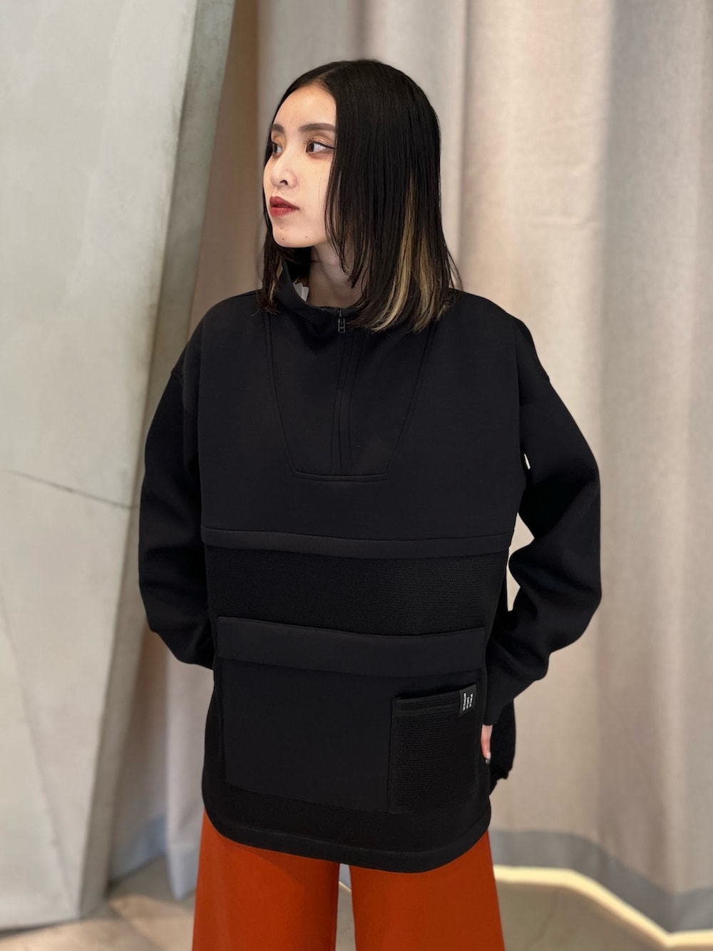 ブラック系のスウェット、オレンジ系のその他パンツ、ブラック系のブーツを着用したレディースの秋コーディネートの4枚目の写真