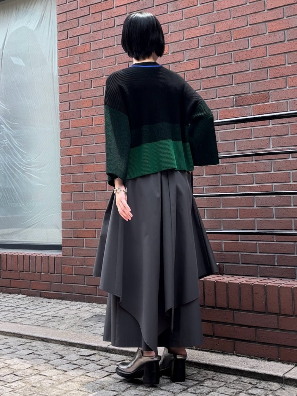 ブラック系のニット/セーター、グレー系のその他パンツ、シルバー系のパンプスを着用したレディースの夏コーディネートの4枚目の写真