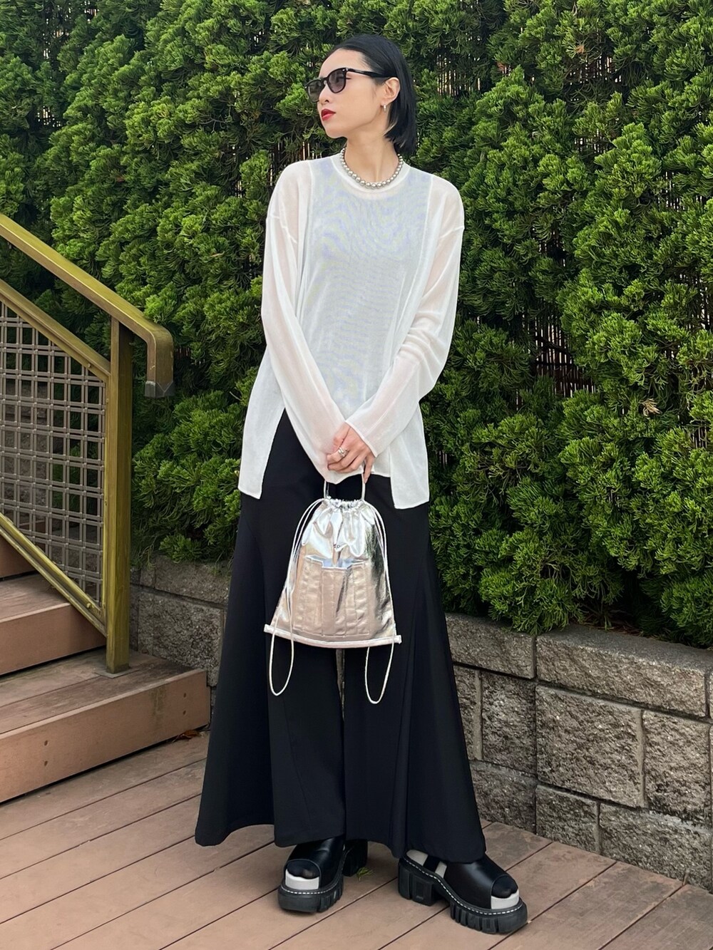 ホワイト系のニット/セーター、ブラック系のその他パンツ、シルバー系のショルダーバッグを着用したレディースの春コーディネートの2枚目の写真