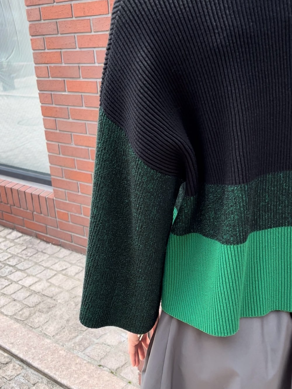 ブラック系のニット/セーター、グレー系のその他パンツ、シルバー系のパンプスを着用したレディースの夏コーディネートの6枚目の写真