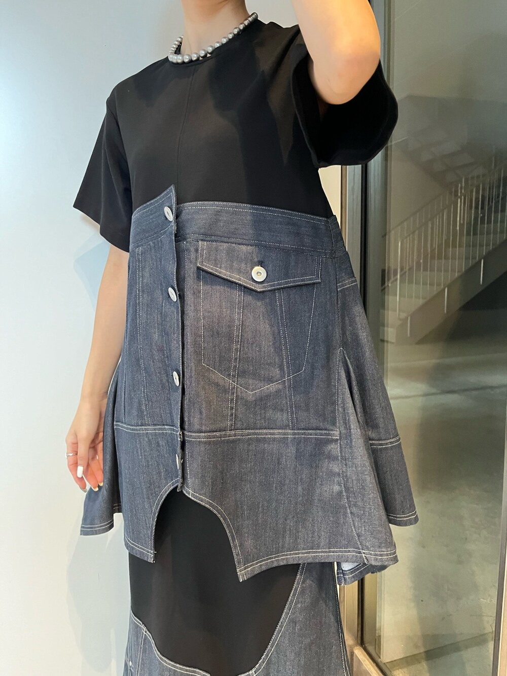 ブルー系のスカート、ブルー系のTシャツ/カットソー、ブラック系のブーツを着用したレディースの冬コーディネートの6枚目の写真