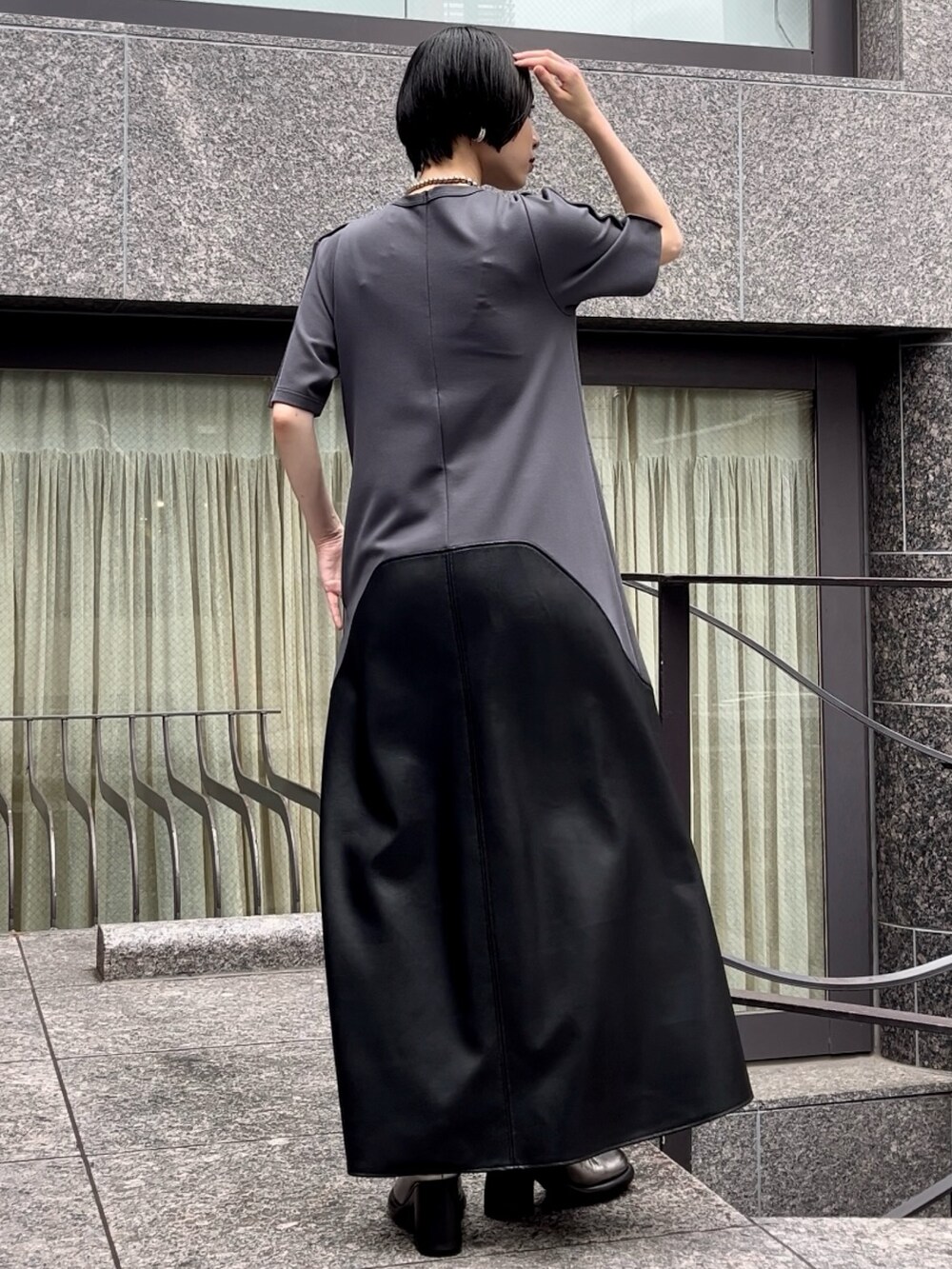 グレー系のワンピース、シルバー系のブーツ、シルバー系のネックレスを着用したレディースの夏コーディネートの4枚目の写真