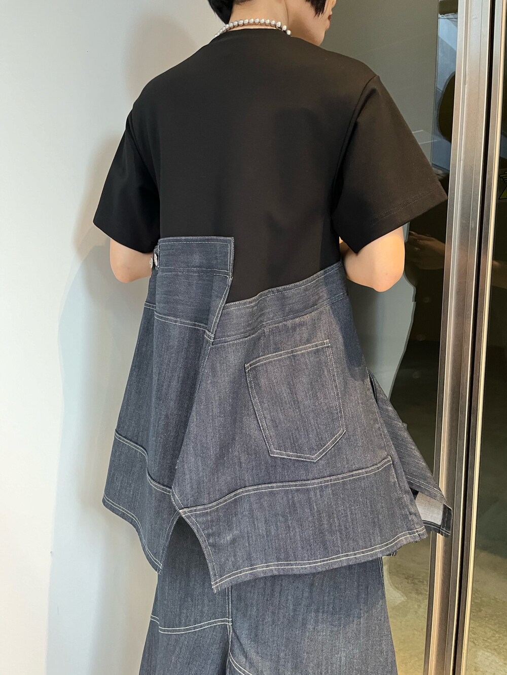 ブルー系のスカート、ブルー系のTシャツ/カットソー、ブラック系のブーツを着用したレディースの冬コーディネートの8枚目の写真