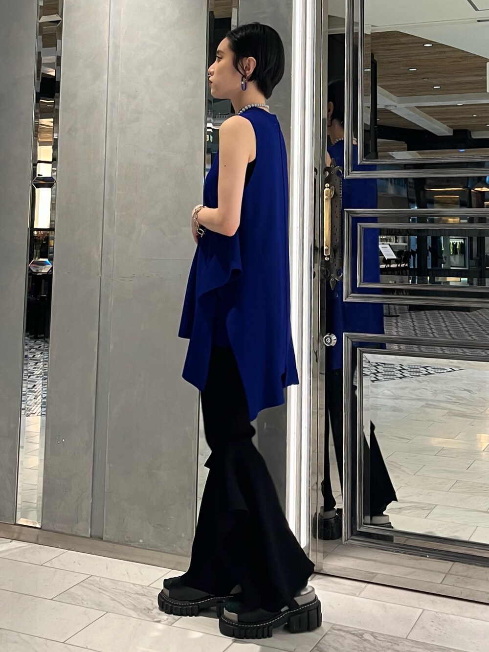 ブルー系のニット/セーター、ブラック系のその他パンツ、その他のサンダルを着用したレディースの春コーディネートの3枚目の写真