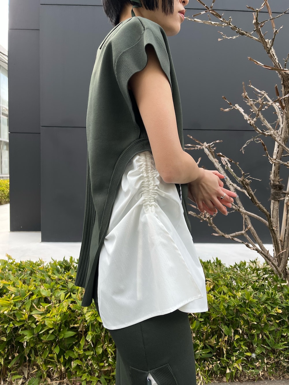 グリーン系のニット/セーター、グリーン系のスカート、ベージュ系のブーツを着用したレディースの春コーディネートの9枚目の写真