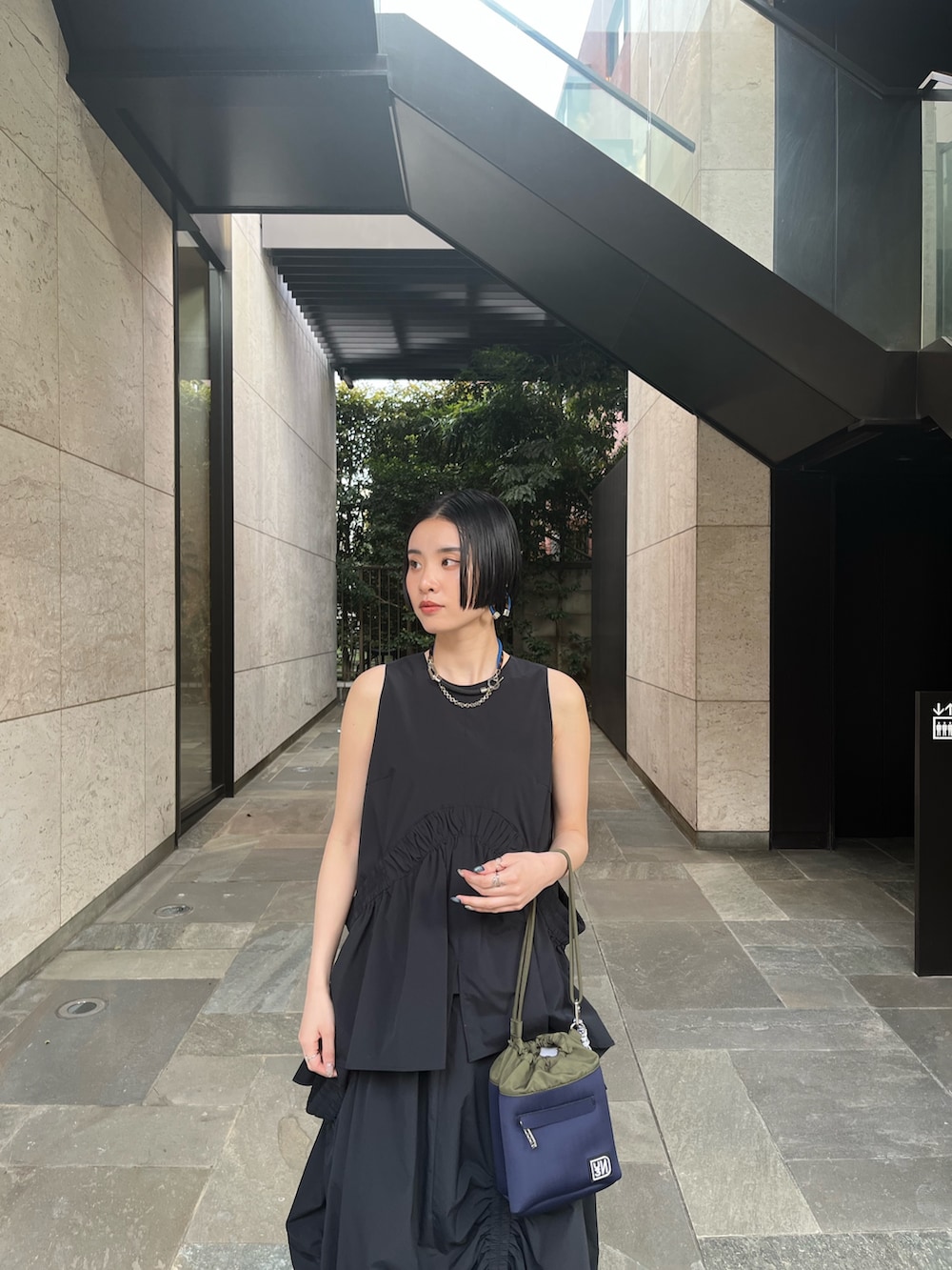 ブラック系のタンクトップ、ブラック系のスカート、ブラック系のサンダルを着用したレディースの春コーディネートの5枚目の写真